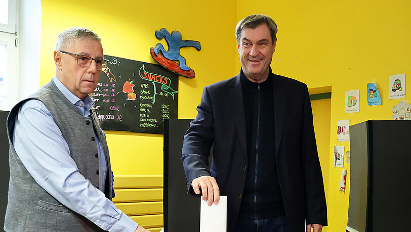 Markus Söder (CSU, r), Ministerpräsident von Bayern, gibt in einem Wahllokal in Nürnberg seine Stimme ab.