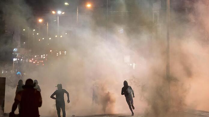 Demonstranten in Bethlehem fliehen vor den &auml;tzenden Schwaden der Tr&auml;nengaskanister, die die israelische Grenzpolizei gegen sie eingesetzt hatte.
