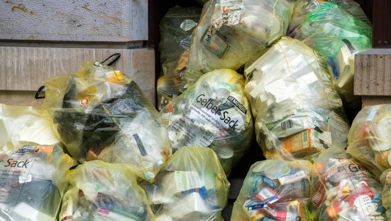 Müllbeutel "Gelber Sack" liegen auf einem Fußweg vor einem Haus. Müllbeutel "Gelber Sack" liegen auf einem Fußweg vor einem Haus.
