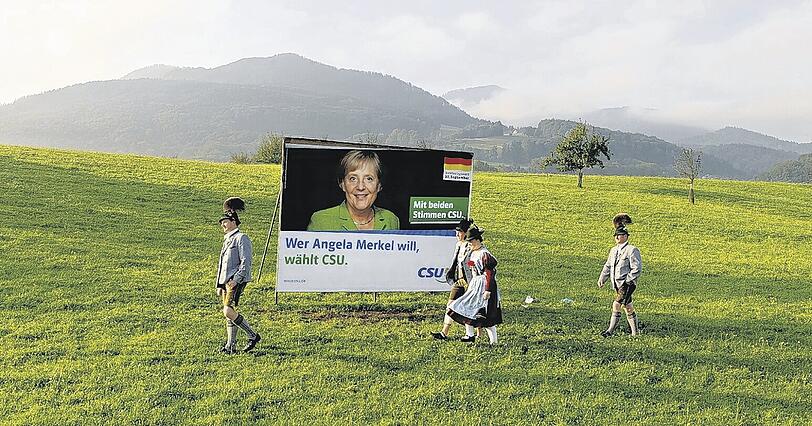 Die Wahl ist gelaufen: Vier Trachtler vor einem CSU-Plakat in Aschau im Chiemgau.Foto: dpa