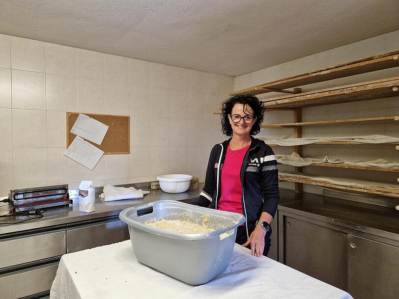 Angelika hat den Teig f&uuml;rs Breatl vorbereitet, im Hintergrund liegt das mit Leinen bedeckte und mit Kleie bestreute Brett f&uuml;r die geformten Brote.