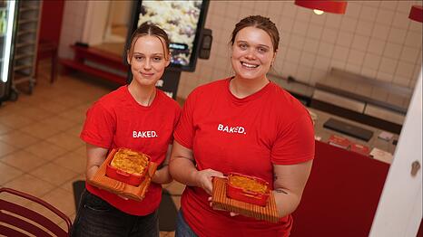 Hannah Eicher (r.) und Mitarbeiterin Lara pr&auml;sentieren die Aufl&auml;ufe bei Baked. In dem Lokal in der Maxvorstadt gibt es ausschlie&szlig;lich Gerichte aus dem Ofen.