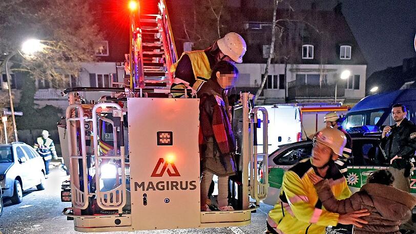 Ein Bild vom 15. März: Feuerwehrmänner bringen Bewohner der Flüchtlings-Wohnanlage in Sicherheit.