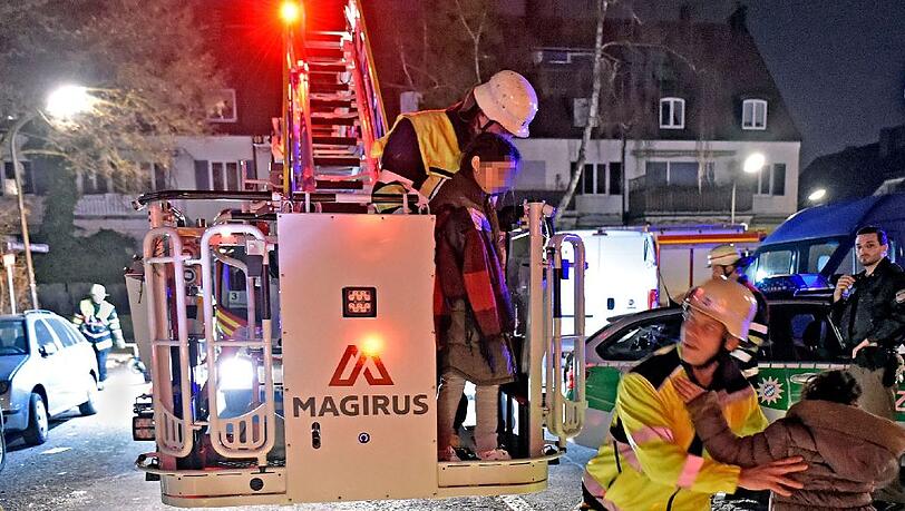 Ein Bild vom 15. März: Feuerwehrmänner bringen Bewohner der Flüchtlings-Wohnanlage in Sicherheit. Ein Bild vom 15. März: Feuerwehrmänner bringen Bewohner der Flüchtlings-Wohnanlage in Sicherheit.