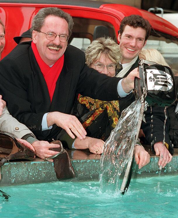 Noch ohne Werbung am Brunnenrand: Münchens Oberbürgermeister Christian Ude (SPD, l) wäscht am Mittwoch (25.2.1998) im Beisein von Bürgermeisterin Gertraud Burkert und Faschingsprinz Florian Drasch (r) im Fischbrunnen am Münchner Marienplatz den Geldbeutel der Stadt. (Archiv) Noch ohne Werbung am Brunnenrand: Münchens Oberbürgermeister Christian Ude (SPD, l) wäscht am Mittwoch (25.2.1998) im Beisein von Bürgermeisterin Gertraud Burkert und Faschingsprinz Florian Drasch (r) im Fischbrunnen am Münchner Marienplatz den Geldbeutel der Stadt. (Archiv)