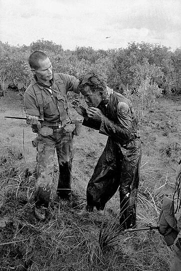 Ein Südvietnamesischer schlägt einen Bauern mit dem Ende eines Dolches. Er soll angeblich Regierungstruppen fehlerhafte Informationen über die Bewegung des Vietcong gegeben haben.