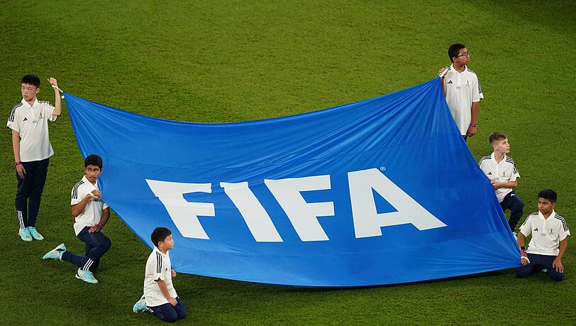 Kinder halten ein Banner mit der Aufschrift "FIFA".
