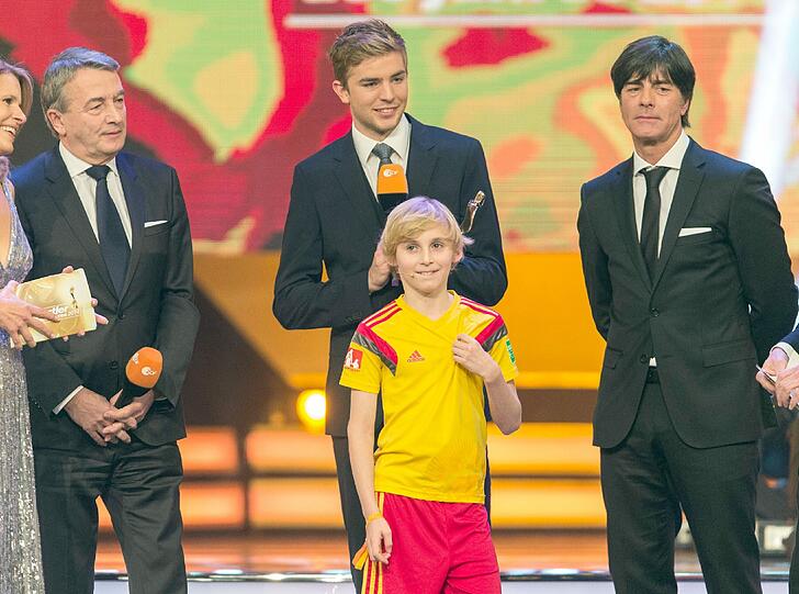 Balljunge Lukas überreichte der DFB-Elf, vertreten durch Wolfgang Niersbach, Christoph Kramer und Joachim Löw, den Preis für die "Mannschaft des Jahres".