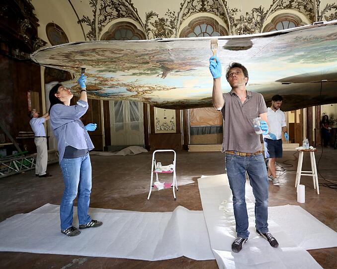 Arbeit über Kopf: Im historischen Silbersaal richten Restauratoren das alte Deckengemälde wieder her.