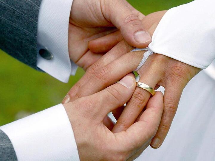 Bei der Trauung streift der Bräutigam der Braut einen Ehering über den Ringfinger. Foto: Andreas Lander/dpa-Zentralbild/dpa/Archivbild