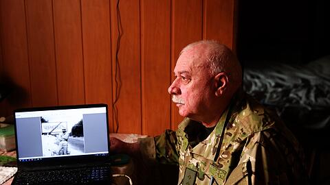 Andriy Kulish mit einem Foto, das ihn zu Beginn des Einsatzes am Ortsausgang von Tschernobyl zeigt.