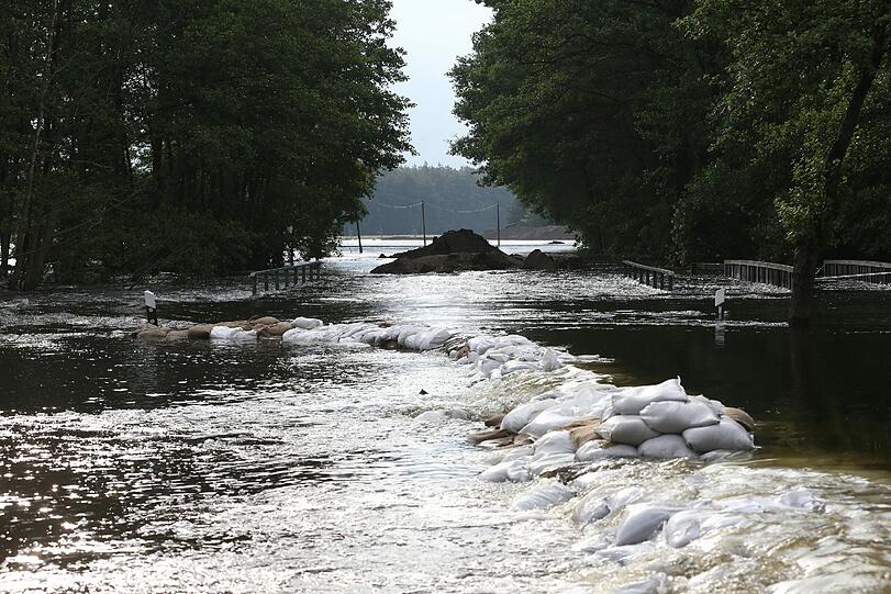 Ein Hilfsdamm aus Sandsäcken ist am 14.06.2013 auf einer Landstraße zwischen Wulkau (Sachsen-Anhalt) und dem Nachbarort Kamern vom Hochwasser überspült.