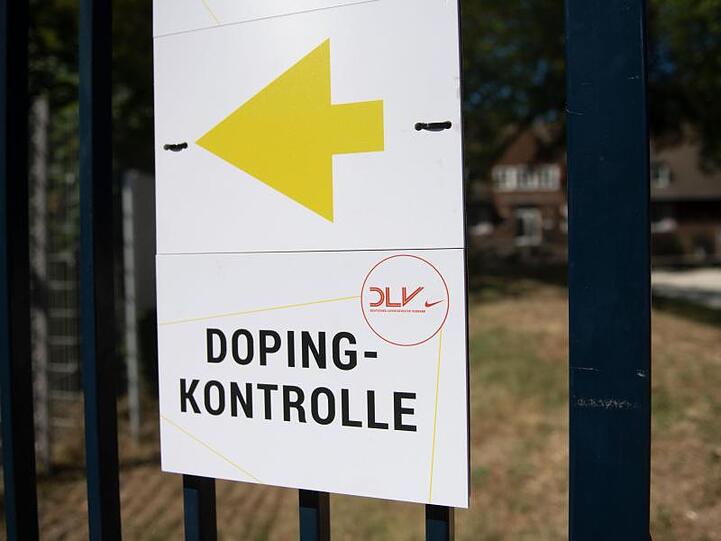 Ein Schild weist den Weg zur Dopingkontrolle. Foto: Bernd Thissen/Archivbild