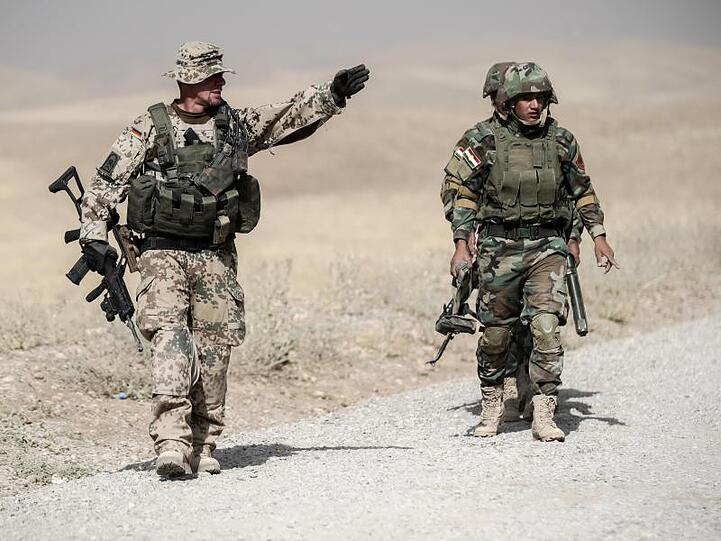 Bundeswehrsoldaten und kurdische Peshmerga Soldaten gehen in der Ausbildungseinrichtung Bnaslawa bei einer Übung am Rand einer Straße entlang. Nun prüft die Bundesregierung den Teilrückzug der Soldaten aus Erbil.
