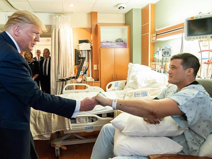 Trump reicht einem Überlebenden des Massakers von Dayton die Hand.