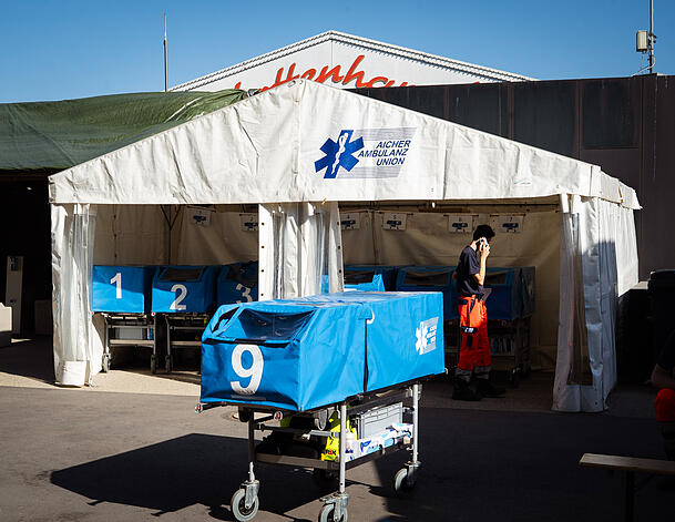 Hinter der Sanit&auml;tsstation stehen mehrere Notfallwagen samt Ausr&uuml;stung bereit.
