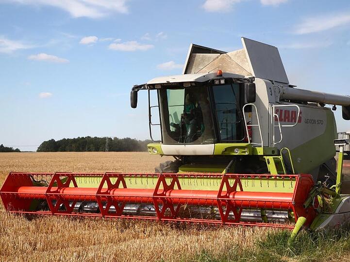 Ein Mähdrescher verrichtet Arbeit auf dem Feld. Foto: Bodo Schackow/dpa-zentralbild/dpa/archiv