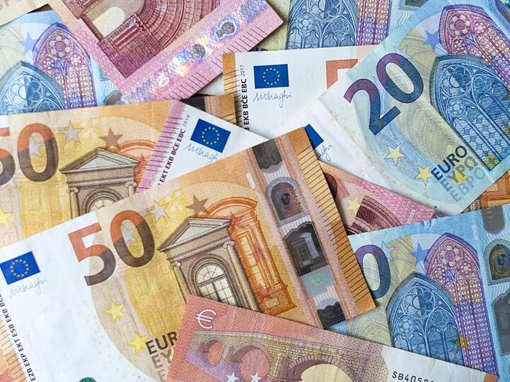 Zahlreiche Banknoten von 10, 20 und 50 Euro liegen auf einem Tisch. Foto: Monika Skolimowska/Archivbild