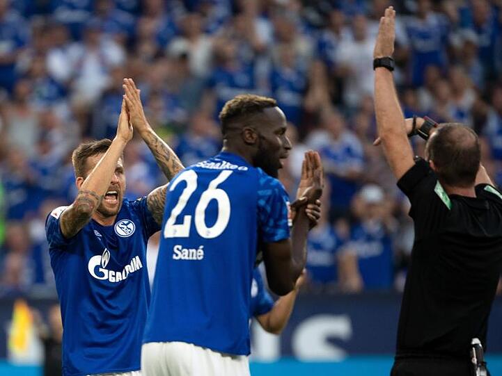Die Schalker Guido Burgstaller und Salif Sané forderten bei Schiedsrichter Marco Fritz (l-r) ein Handspiel.
