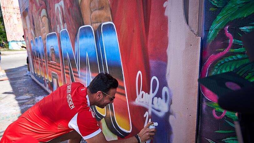 Claudio Pizarro signiert das Kunstwerk mit einer Spraydose.