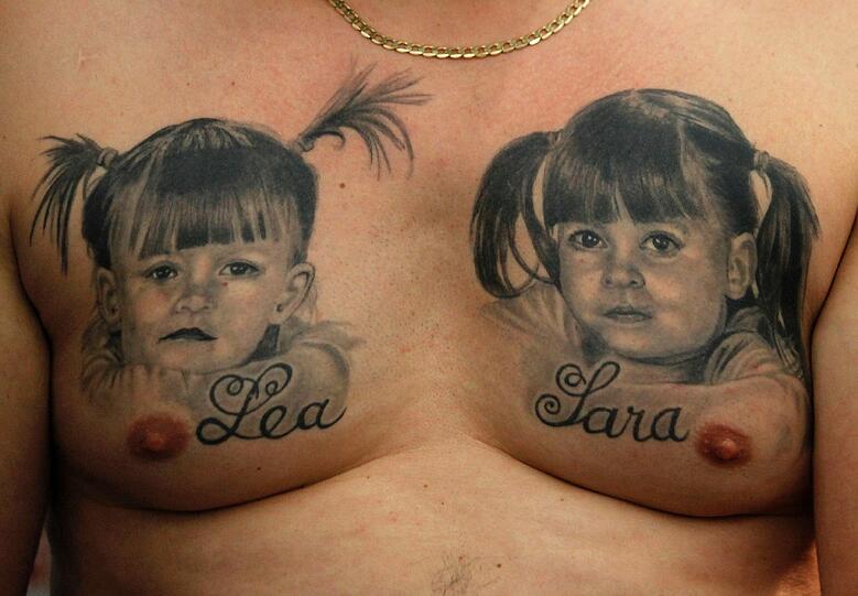 Dieser Mann zeigt sein Tattoo auf der Brust mit seinen Kindern Lea und Sarah.