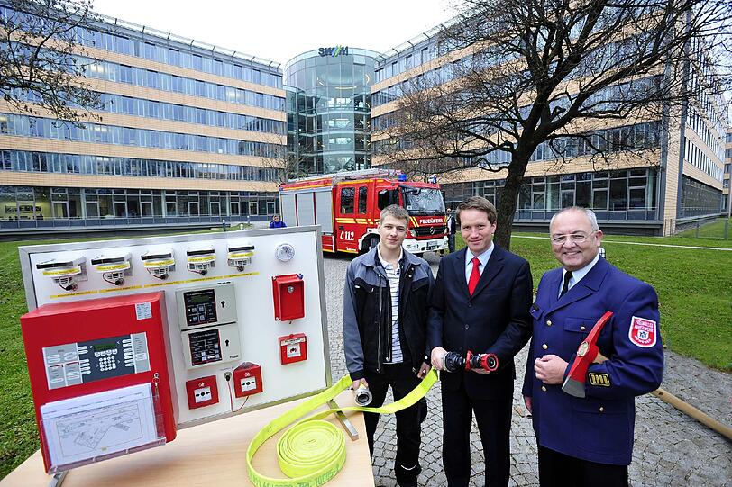 Stadtwerke unterstützen die Freiwillige Feuerwehr: 
Die Stadtwerke München überreichen in Person des kaufmännischen Geschäftsführers Dr. Florian Bieberbach der Freiwilligen Feuerwehr München eine umgebaute, ausgediente Brandmeldeanlage zu Übungszwecken. Stadtbrandrat Rupert Saller nimmt sie entgegen.