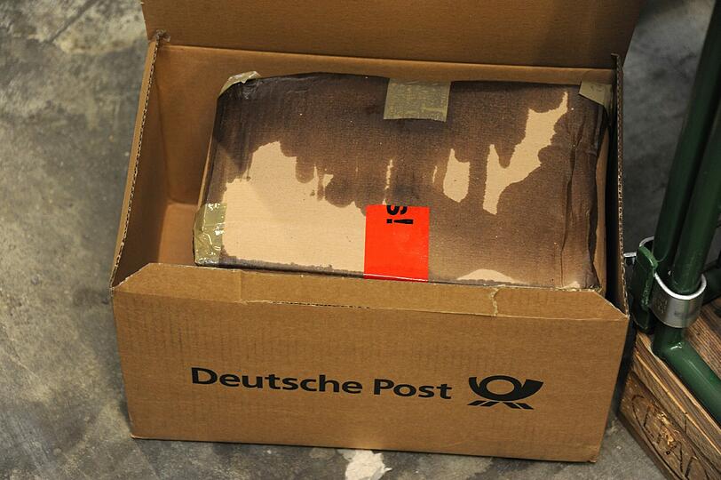 In diesem Päckchen ist eine Weinflasche kaputt gegangen. Aufgeweicht und tropfend kommt die Sendung in Aschheim an. Solche und ähnliche Fälle landen...