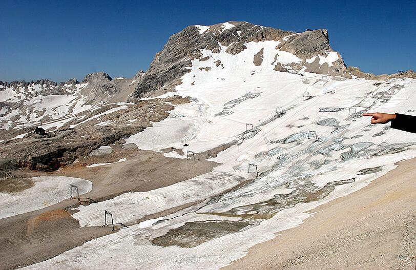 Eine Hand zeigt an der Zugspitze bei Grainau (Oberbayern) auf den Schneeferner-Gletscher.