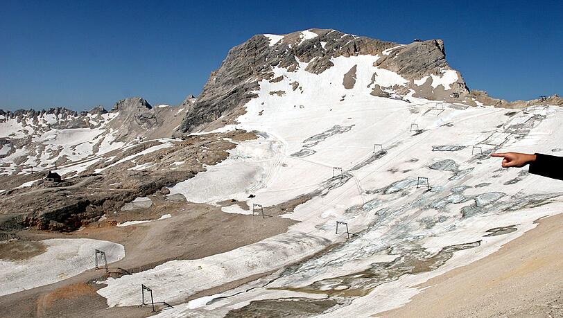 Eine Hand zeigt an der Zugspitze bei Grainau (Oberbayern) auf den Schneeferner-Gletscher.