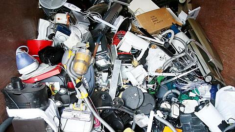 Ausrangierte Haushaltsger&auml;te und andere Elektroger&auml;te in einem Sammelbeh&auml;lter f&uuml;r Elektroschrott.