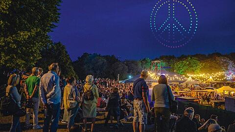 Ein Friedenszeichen im Himmel - und auf dem Sommertollwood-Festival singen Tausende mit. Das könnte ein Gänsehaut-Moment werden.