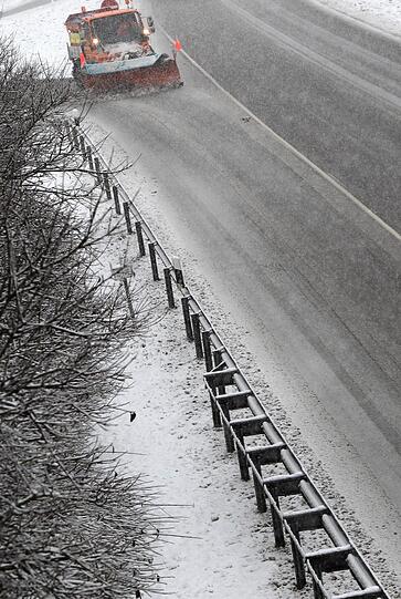 Ein Räumfahrzeug kehrt den Schnee von der Bundesstraße 12 bei Geisenried (Bayern).