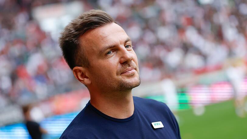 Trainer Enrico Maaßen vom FC Augsburg steht vor Spielbeginn auf dem Spielfeld.