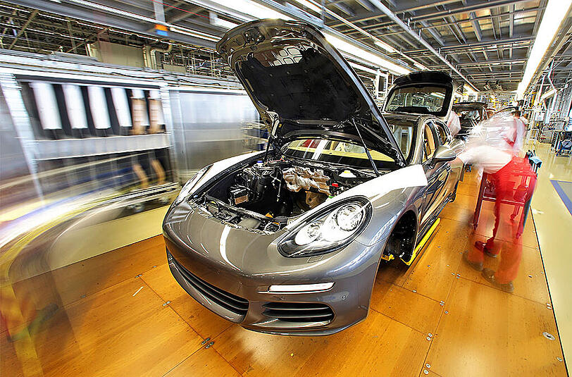 Mitarbeiter arbeiten an einem Panamera in der Produktion der Porsche AG in Leipzig.