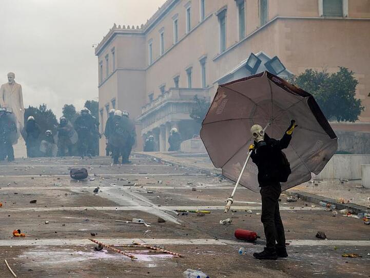 Gut abgeschirmt und mit einer Gasmaske gegen Tränengas geschützt: Ein Demonstrant bei den Unruhen in Athen.