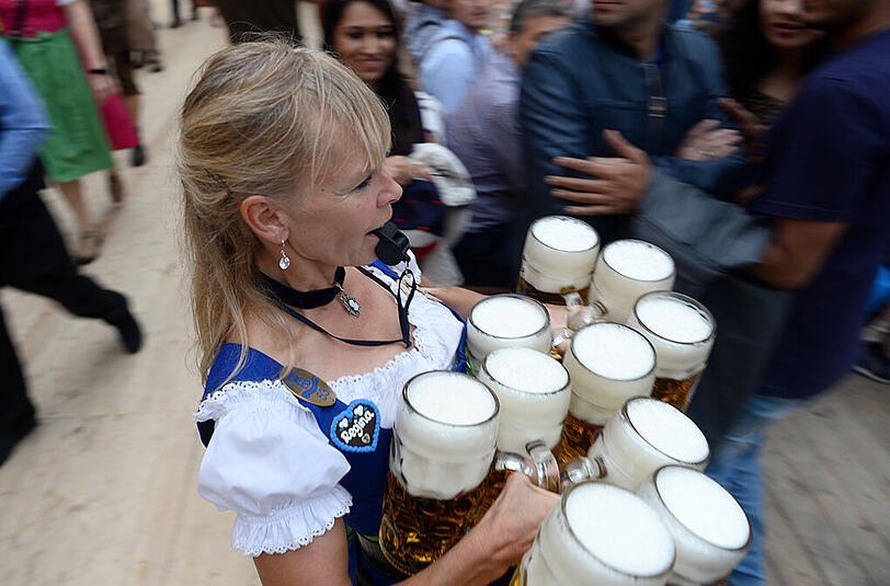Platz da! - Eine Wiesnbedienung pfeift sich im Hofbräuzelt den Weg frei.