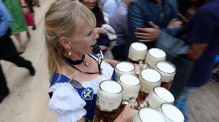 Platz da! - Eine Wiesnbedienung pfeift sich im Hofbräuzelt den Weg frei.