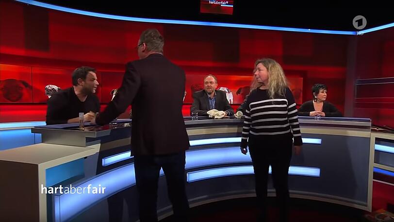 Eine Feministin (re.) platzt zu Moderator Frank Plasberg (Mitte). Martin Rütter (li.) diskutiert mit ihr.