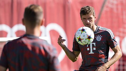 Bayerns Thomas Müller (r) und Joshua Kimmich halten im Training den Ball hoch.