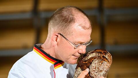 Stefan Keller, Bäckermeister und Brotsommelier, riecht an einem frischen Brot.