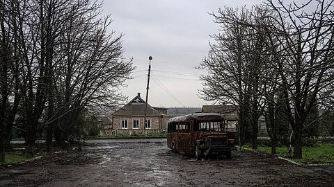 Ein ausgebrannter Bus steht auf einer Straße.