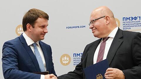 Maxim Oreschkin (l), russischer Minister für wirtschaftliche Entwicklung, und Bundeswirtschaftsminister Peter Altmaier reichen sich in St. Petersburg die Hände.