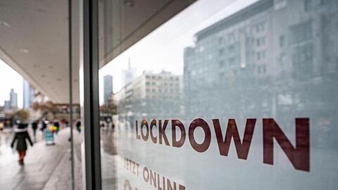 "Lockdown" steht im Schaufenster eines geschlossenen Kaufhauses, das darunter zum Online-Einkauf rät.