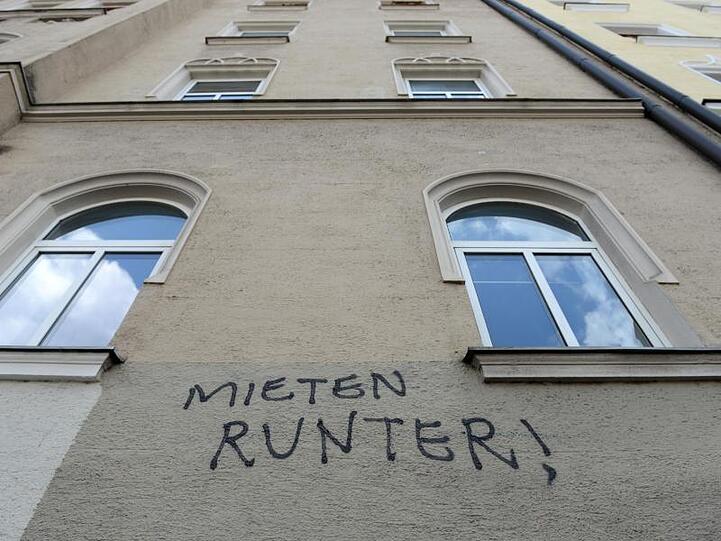 "Mieten runter!" steht an einer Hausfassade. Foto: Andreas Gebert/Archivbild