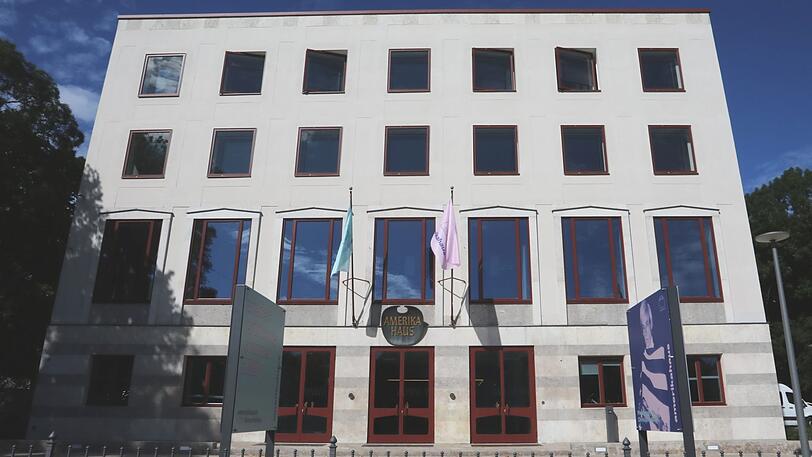 So sieht das Gebäude von außen aus. Statt einer US-Flagge hängen nun eine türkise und eine flamingofarbene Flagge.