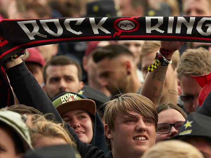 Ein Festivalbesucher hält einen Schal mit der Aufschrift "Rock am Ring" im Publikum. Foto: Thomas Frey/dpa/Archivbild