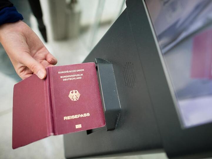 Eine Frau hält einen Reisepass an das Lesegerät eines EasyPass-Systems am Flughafen in München. Foto: Matthias Balk/Archiv