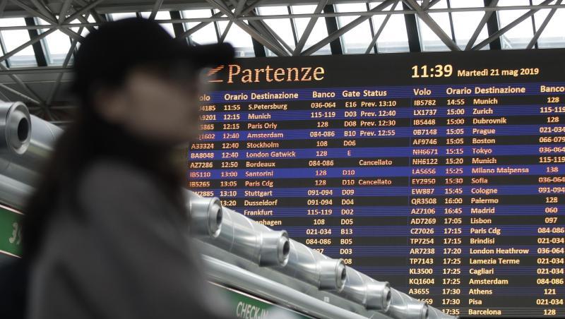 Ein Passagier steht vor einer Fluginformationstafel am Flughafen Rom-Fiumicino. Ein Passagier steht vor einer Fluginformationstafel am Flughafen Rom-Fiumicino.