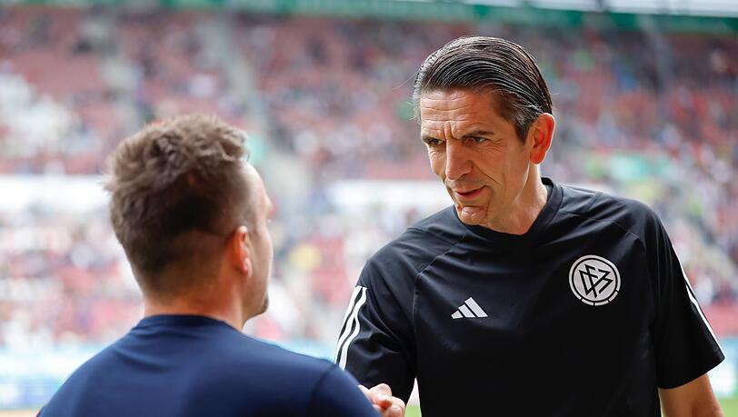 Deniz Aytekin (r) begrüßt vor Spielbeginn Augsburg-Trainer Maaßen vor einem Spiel.