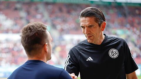 Deniz Aytekin (r) begrüßt vor Spielbeginn Augsburg-Trainer Maaßen vor einem Spiel.